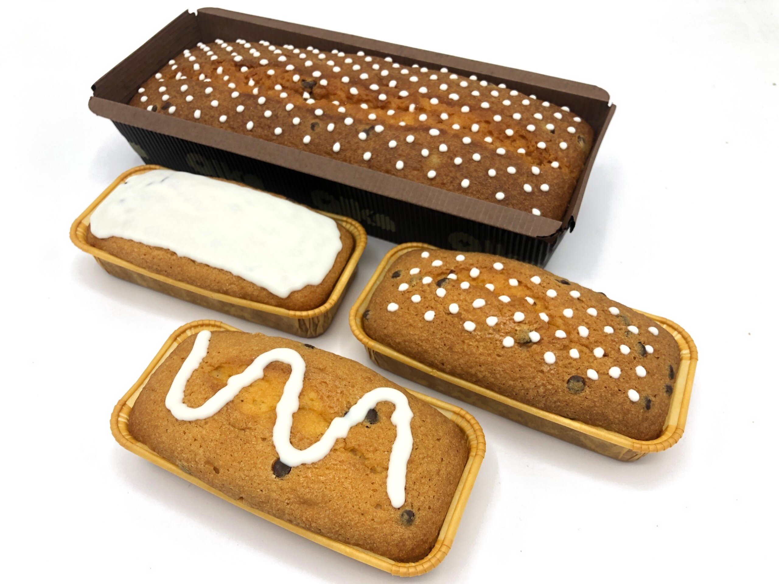 A large loaf cake with white dots and three small loaf cakes with a white layer, white dots and a wave line