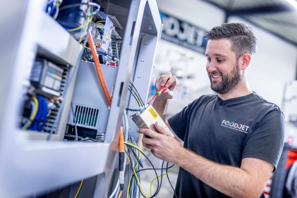 FoodJet engineer wiring a control cabinet during machine assembly